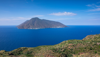 Coast with grass fields of Lipari with view to volcano islands Salina, Alicudi, Filicudi during blue sky day, Sicily Italy.