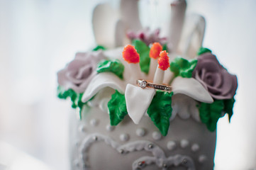 Gold wedding ring with gemstone on the cake