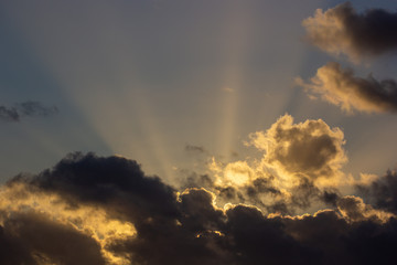 Fototapeta na wymiar sunset rays behind the clouds