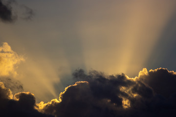Fototapeta na wymiar sunset rays behind the clouds