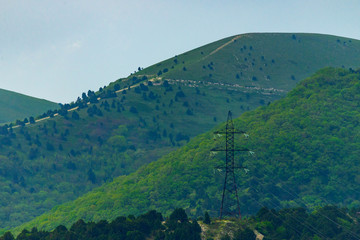 Obraz premium High voltage power lines in mountain forest