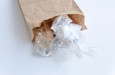 Brown ecological paper bag with plastic and paper rubbish waste inside. Isolated on white background. Collecting and recycling rubbish concept