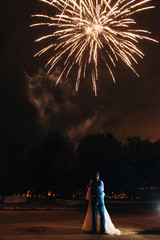 Beautiful wedding couple on the background of the fire show in love and hug