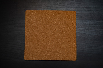 Fototapeta premium square cork base on the dark wooden table