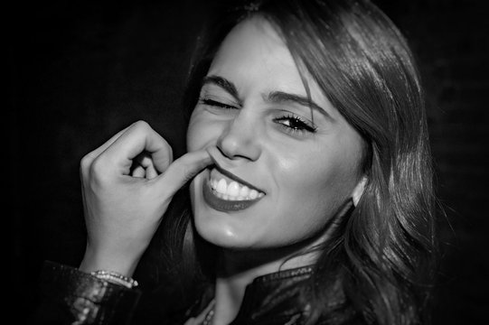 Portrait Of Smiling Woman Showing Teeth Against Black Background