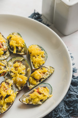 Stuffed Baked Mussels  (Baked Tahong) with Butter, Cheese and Garlic - Close up with pepper and salt shaker
