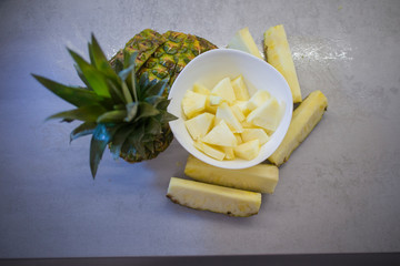 sliced fresh pineapple in a white plate on the kitchen