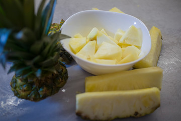 sliced fresh pineapple in a white plate on the kitchen