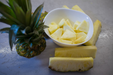 sliced fresh pineapple in a white plate on the kitchen