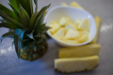 sliced fresh pineapple in a white plate on the kitchen