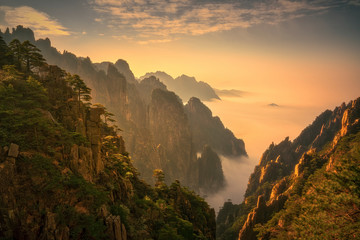 The warm late afternoon sunlight shine on Mt.Huangshan with clouds and fogs in the valley, the most...
