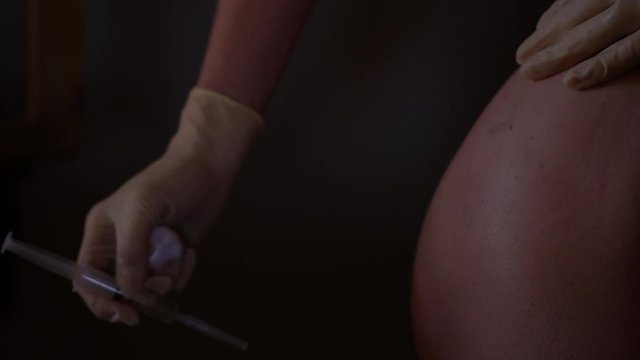 Injection for buttocks. Antibiotics self-injection at home. Woman hands holding needle.