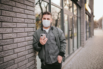 Young man with mask on face in city center at quarantine time