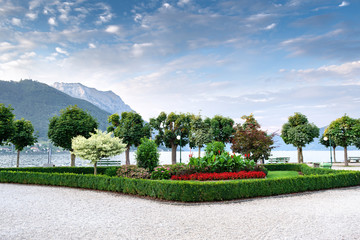 View of the embankment on the lake against the backdrop of mountains and blue sky with beautiful clouds. Concept landscape, landscape design.
