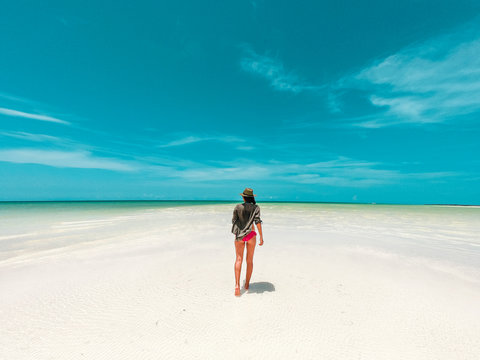 Mujer caminando en bancos de arena Isla Holbox