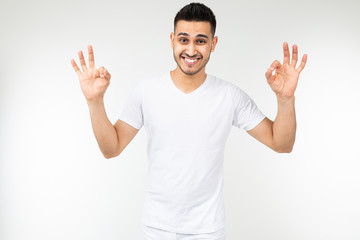 Naklejka premium smiling guy in a white t-shirt with a mockup on a white background