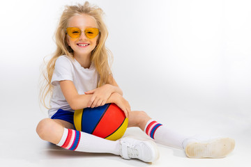 teenager girl in sports shorts with a basketball on a white background