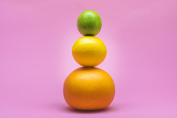 Fresh lime, lemon, grapefruit, orange isolated on a pink background. Summer and seasonal fruits for a healthy lifestyle. Health care.