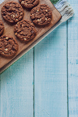 Chocolate cookies with a glass of milk on the light green wooden table in top view
