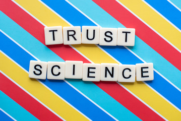 Trust Science letter tiles on colorful background