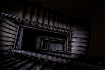 High angle above view down of old vintage staircase winding spiral in Lviv, Ukraine, Europe with nobody architecture dark low-key abstract pattern