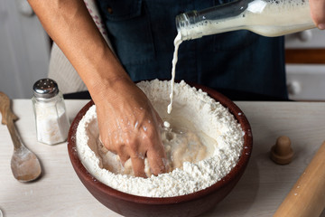 hands kneading flour, yeast eggs bakery ingredients milk honey in home kitchen