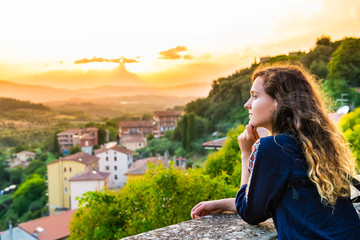 Chiusi, Italy cityscape rolling hills view in Tuscany and young woman looking at sunset view in summer