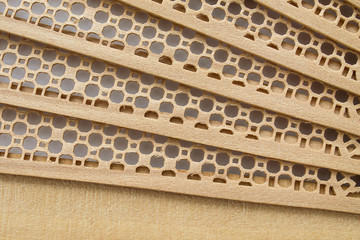 Folding part wooden fan. Light background, close-up. Asian traditions, china and japan. Wood and lace.