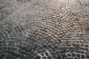 The dark gray paving stones laid out in a semicircle. The texture of the old dark stone. Road...