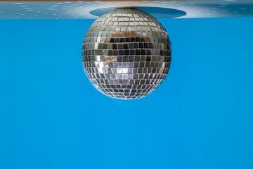 Mirror ball hanging from the ceiling in a bright modern blue room.