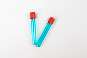 Medical test tube with blue liquid on white background