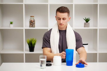 Man prepares a protein shake in the shaker after training.