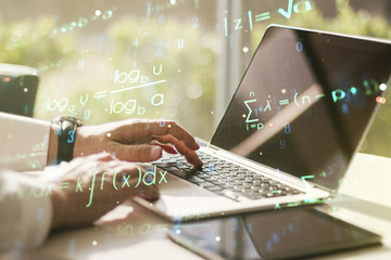 Double exposure of creative scientific formula concept with hands typing on laptop on background, research and development concept