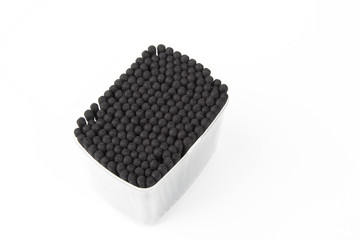 charcoal cotton buds in box on white background.