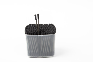 charcoal cotton buds in box on white background.