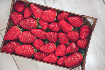 box of huge fresh red raw strawberries.