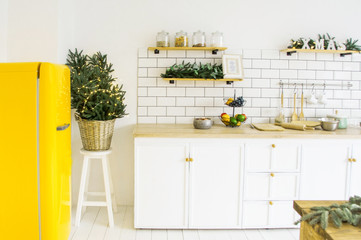  beautiful white cosy modern kitchen interior,kitchenware, home style, with bright yellow fridge , christmas decorations