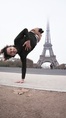a young handsome man doing a handstand in Paris in front of tower ,traveling lifestyle