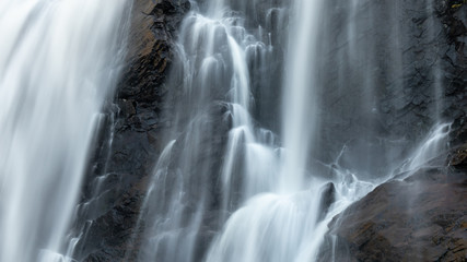 Fototapeta na wymiar Skjervefossen waterfall falling blur water close. Norway nature journey wallpaper view silky powerful white sparkle silky stream 