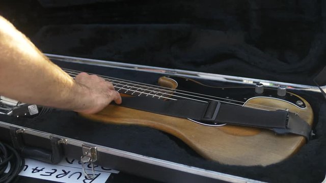 Guitarist puts his guitar in its case after the show