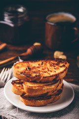 French toasts on white plate over wooden surface