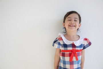 A cute four-year-old asian girl is smiling and acting with the camera. Anyone who sees will feel bright and happy. Photos in the studio on a white background for half body shot with copy space.