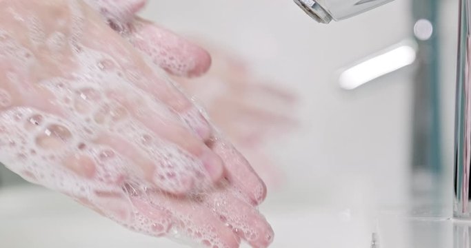 Slow motion, Two people is washing  his hands with a hand wash gel in sink. Coronavirus pandemic prevention wash hands with soap warm with water.  Two person carefully washing hands with soap. Cloesup