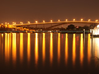 Fototapeta na wymiar Night Long exposure of Gladesville Bridge in Sydney Australia illuminated by the bright lights and smooth harbour waters light up 