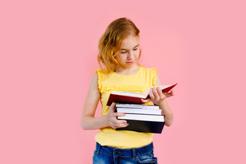 Photo of happy charming blonde girl posing with exercise books and smiling isolated over pink background
