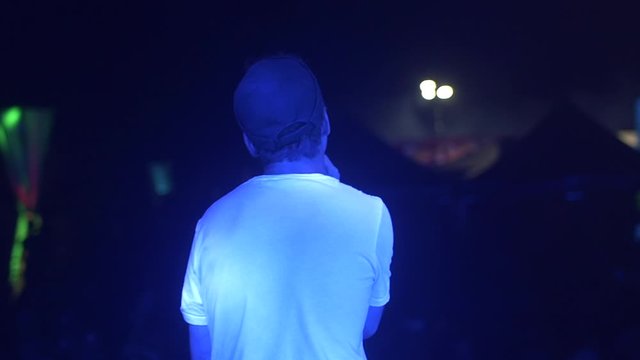 White rapper with a cap on festival stage