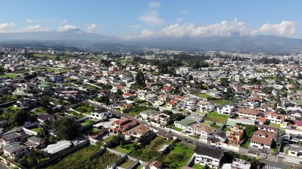 Aerial view over a suburb of Quito, Ecuador, the Valle de Los Chillos. Exceptionally clear sky and absence of smog due to lockdown over the  Coronavirus Covid-19 pandemic. 22 April 2020. - Powered by Adobe