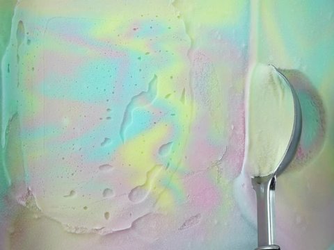 Closeup Scooping ice cream Rainbow colorful flavoured out from container with a spoon, Food concept, Blank for design.