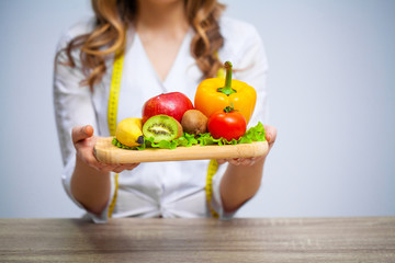 Doctor Nutritionist holding fresh fruits and vegetables for healthy diet.