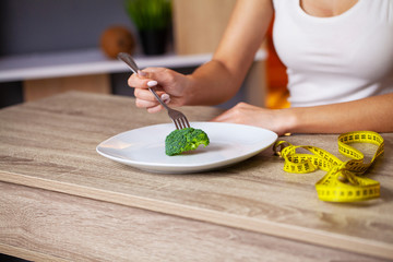 Concept of overweight woman eating broccoli diet.
